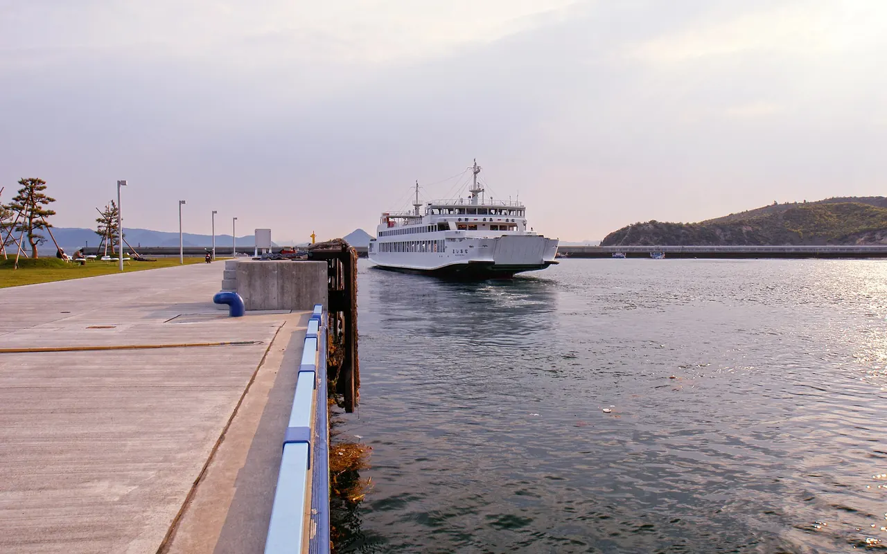 Eine weiße Personenfähre bei der Ankunft im Hafen Miyanoura auf Naoshima